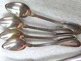 five spoons that are sitting on a table