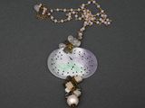 un gros plan sur un collier composé de perles et de perles de verre
