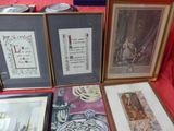 four framed pictures on a red table with a clock
