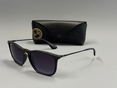 une paire de lunettes de soleil avec son étui, posée sur une surface blanche