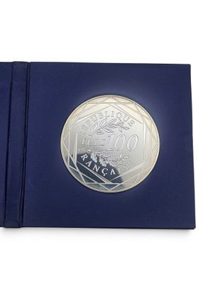 l'image d'une pièce d'argent dans une boîte bleue sur fond blanc
