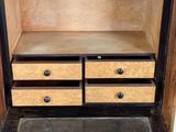 a wooden cabinet with two drawers and a rug on the floor