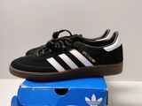 a pair of black and white adidas sneakers sitting on top of a blue box