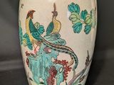 un vase avec un oiseau posé sur une table