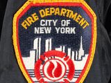 a fire department badge on the back of a fireman ' s jacket