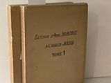 un vieux livre posé sur une table blanche à côté d'un mur blanc
