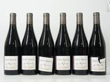 six bouteilles de vin sont alignées sur une table