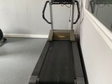 a treadmill in the corner of a room next to a mirror