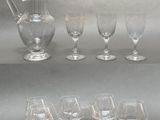 six verres à vin et un pichet posés sur une table