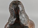 a close up of a statue of a bird on a white surface