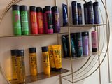 une étagère sur laquelle sont disposés de nombreux produits capillaires de toutes sortes
