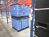 many blue crates stacked on top of each other in a warehouse