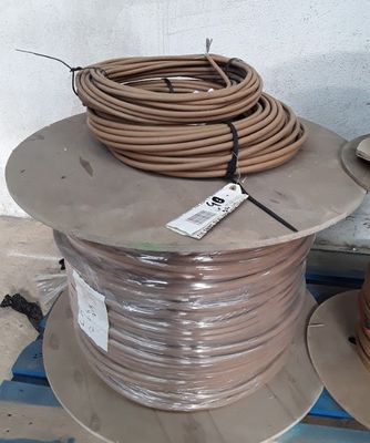 a coil of wire on the ground next to a box of wires