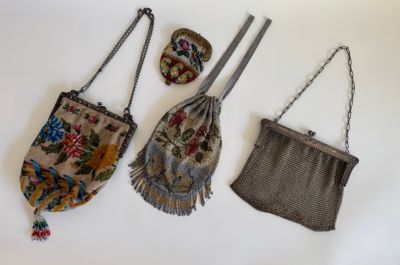 trois petits sacs à main sont accrochés à un mur blanc