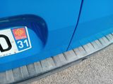 a close up of a blue car with a number plate on it