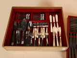 many different types of silverware in a wooden box