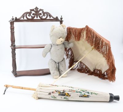 a teddy bear that is standing next to an umbrella