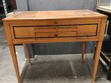 a small wooden table with two drawers on it