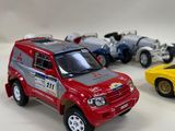 three toy cars are lined up in a row on a white surface