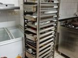 many trays of food sitting on a cart in the kitchen