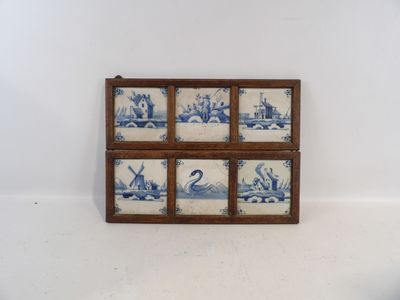 a picture of a blue and white tile in a wooden frame