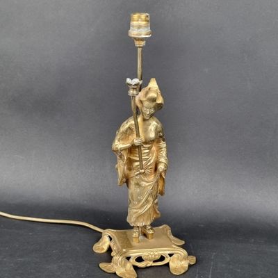 une figurine ancienne en laiton représentant un homme tenant une lampe