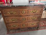 a wooden chest of drawers with a marble top