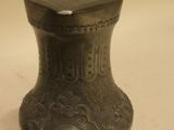 a small metal jar with a lid on a table