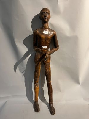 statue en bois représentant un homme tenant un couteau dans chaque main