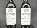 deux bouteilles de vin rouge posées sur une table en bois