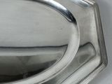 a silver tray with a silver handle on a table