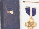 an old book with a purple ribbon and a gold cross on it