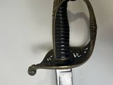 a close up of a sword on a white surface