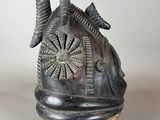 sculpture of a helmet on a stand with a clock on top of it