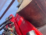 a close up of a red tractor with a big wheel on it ' s back