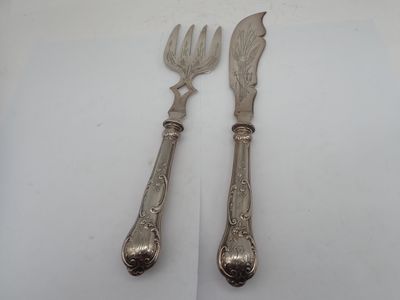pair of silver plated utensils on a white surface