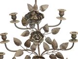 a metal candle holder with a rose on it