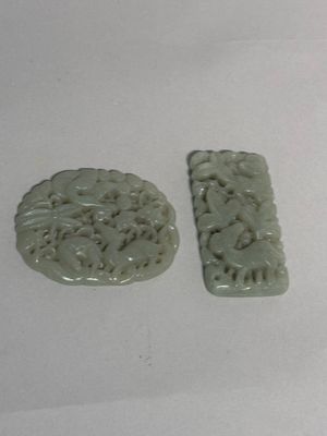 two pieces of green jade on a white surface