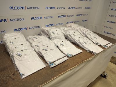 plusieurs chemises blanches sont empilées sur une table devant un mur