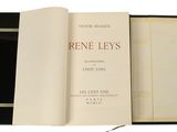 un livre ouvert posé sur une table blanche, à côté d'une boîte noire