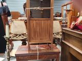 a wooden cabinet with a clock on top of it in a room