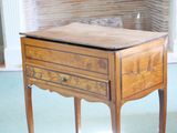 a small wooden table with a drawer on top of it