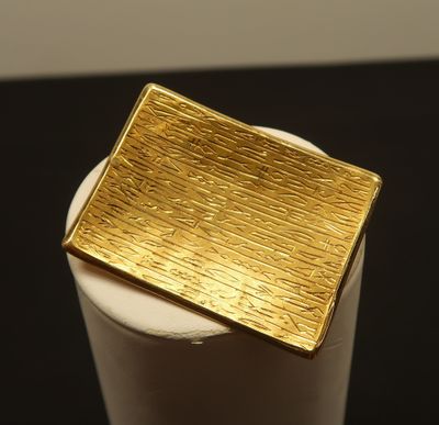a gold plate sitting on top of a white cup