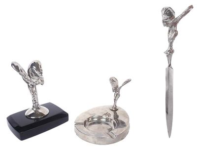 a silver statue of a woman holding a knife next to a pair of scissors