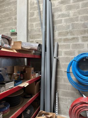 une pièce où s'entassent des tuyaux et des boîtes sur les étagères