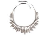 un gros plan d'un collier en argent sur fond blanc