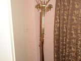 un porte-manteau dans un coin d'une pièce où se trouve un rideau
