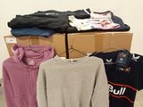 a pile of sweaters and other clothing on display