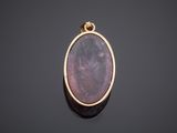 a yellow gold pendant with a purple stone in the center
