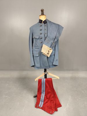 a blue jacket and red pants on a mannequin stand